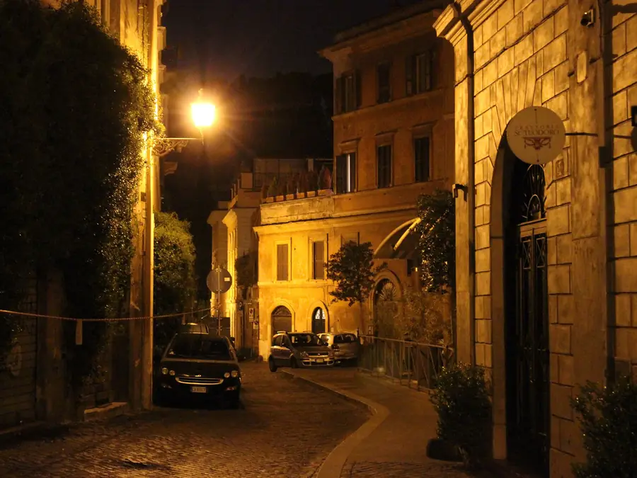 Vicolo romano di sera con lampioni